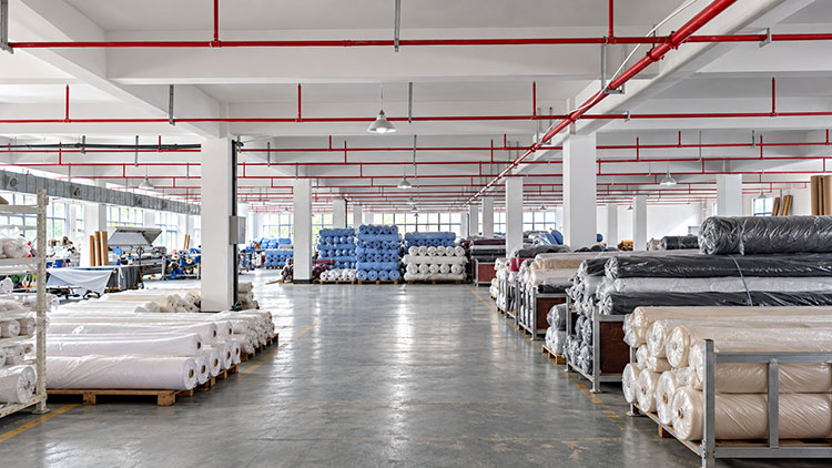 Company History 5 BEGOODTEX flame retardant fabric production area with textile manufacturing equipment and fabric rolls