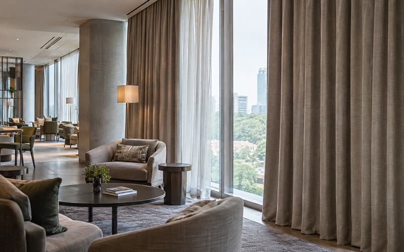 Les 10 principaux fabricants de tissus ignifuges en Chine | Guide d'achat 2026-2030 Tissu d'ameublement ignifugé du sol au plafond, installé dans le salon d'untel moderne pour des applications intérieures contractuelles et des espaces publics.