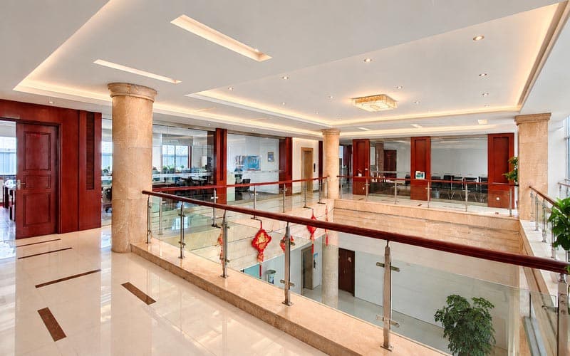 Novo espaço, novo visual! A BEGOODTEX tem uma nova casa! 4 Corredor de escritórios no piso superior da begoodtex com guarda-corpos em vidro e espaço interior aberto